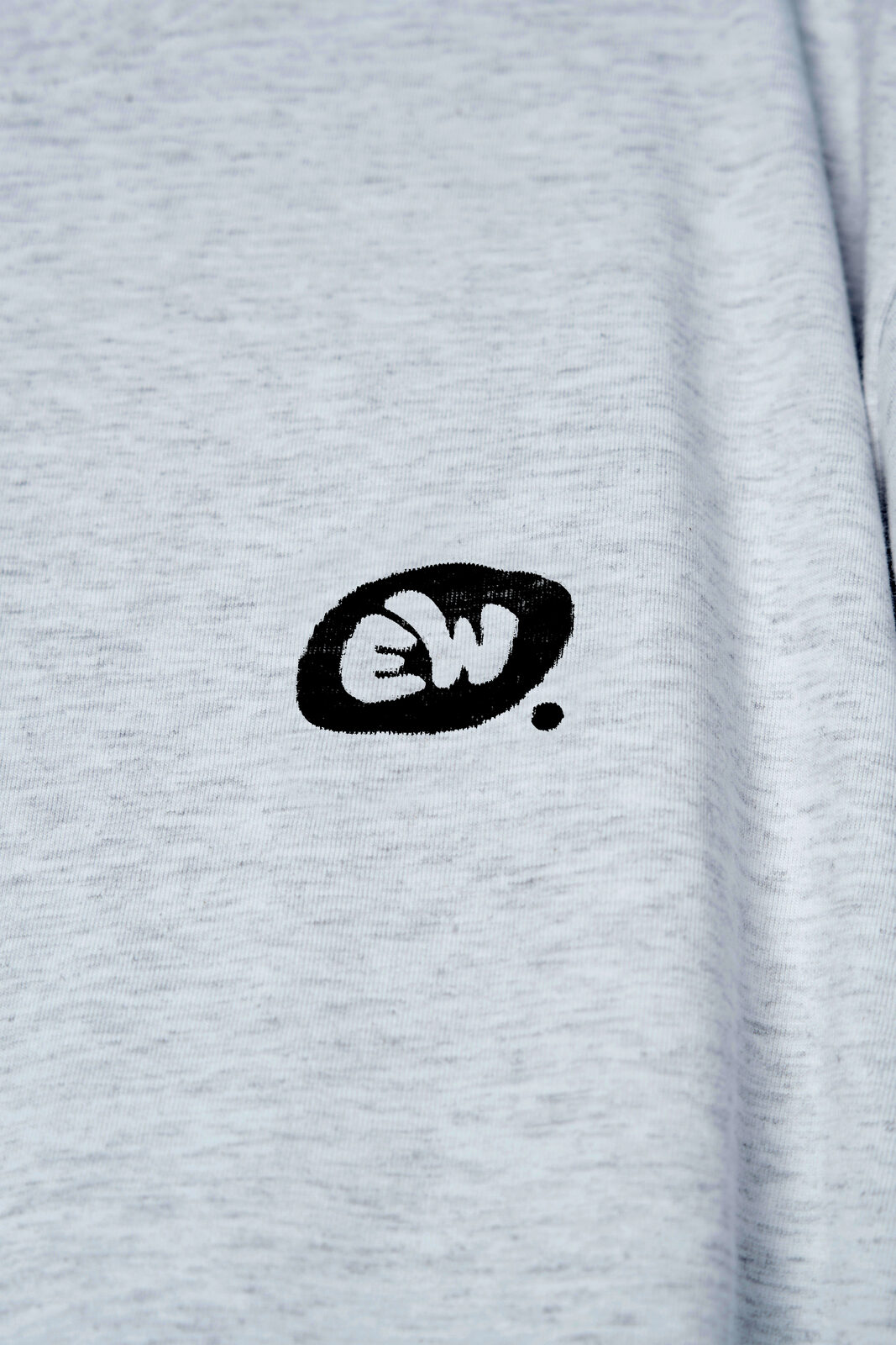 Mockup détail du logo bulle EW imprimé sur textile pour la marque EthikWear